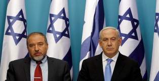 Israel's Prime Minister Netanyahu sits next to Foreign Minister Lieberman after delivering a statement in Jerusalem